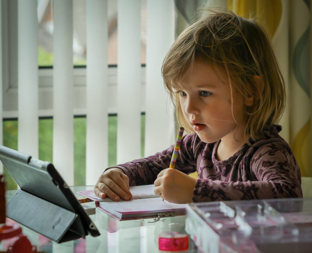 Image that shows a child using an iPad to complete school work. 