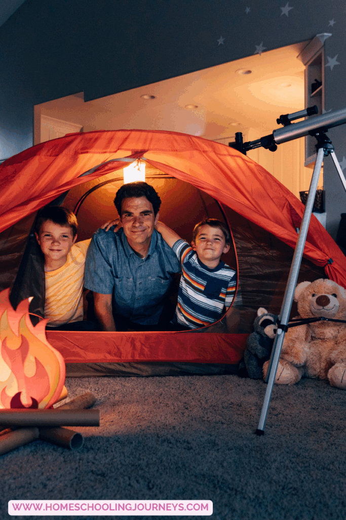 An image of kids camping indoors with dad.