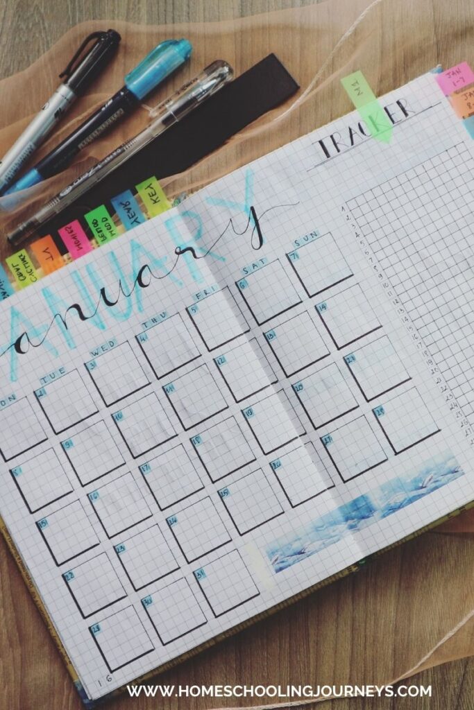 An image of a planner with pens on a table.